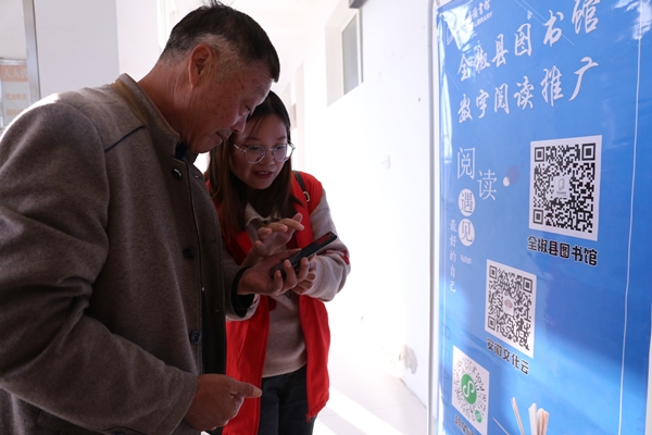 志愿者现场向老人讲解如何使用数字阅读.JPG